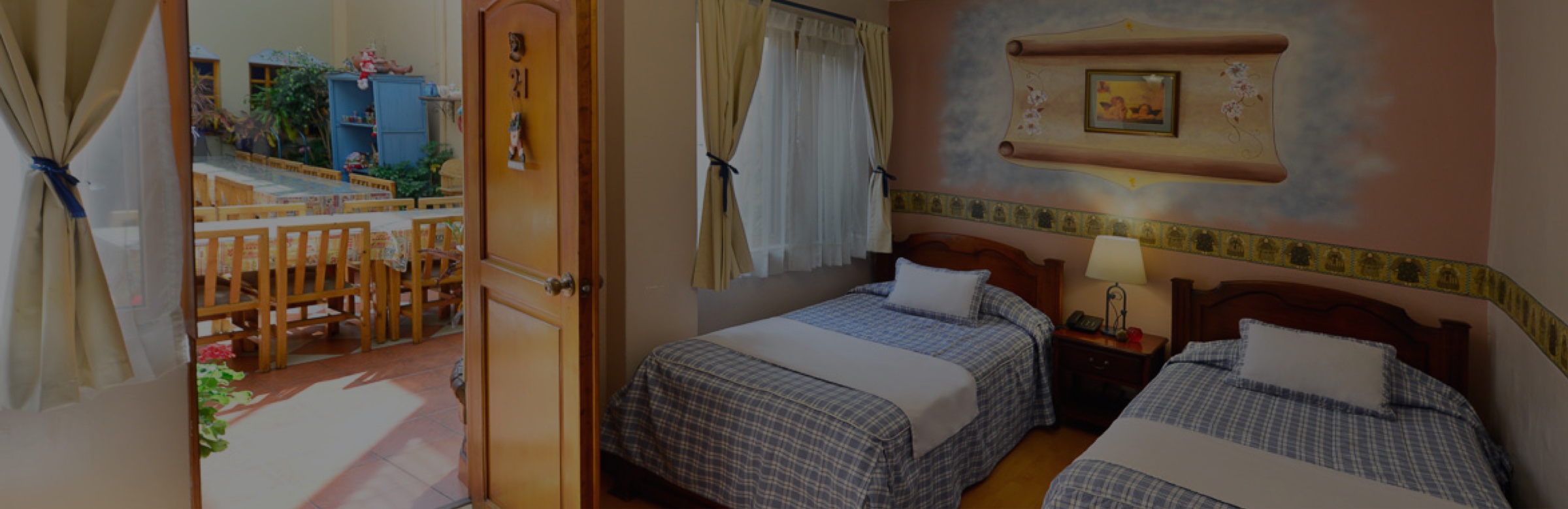 Interior de la habitación 21 en el Hotel Posada del Ángel en Cuenca, Ecuador". Proporciona una descripción concisa y precisa de la imagen, indicando que se trata del interior de una habitación específica en el Hotel.