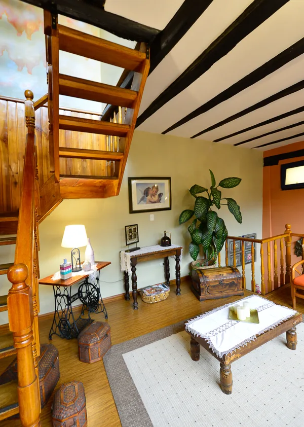 Interior tradicional con escalera de madera en la casona patrimonial del Hotel Boutique Posada del Ángel