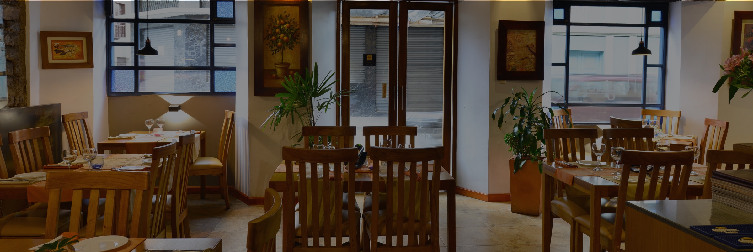 Puerta de entrada al restaurante Mangiare Bene en el Hotel Posada del Ángel en Cuenca, Ecuador". Proporciona una descripción concisa y precisa de la imagen, indicando que se trata de la puerta de entrada al restaurante Mangiare Bene dentro del Hotel.